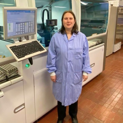 Valérie Poirier, coordonnatrice technique Une femme aux cheveux bruns debout devant un appareil de laboratoire.