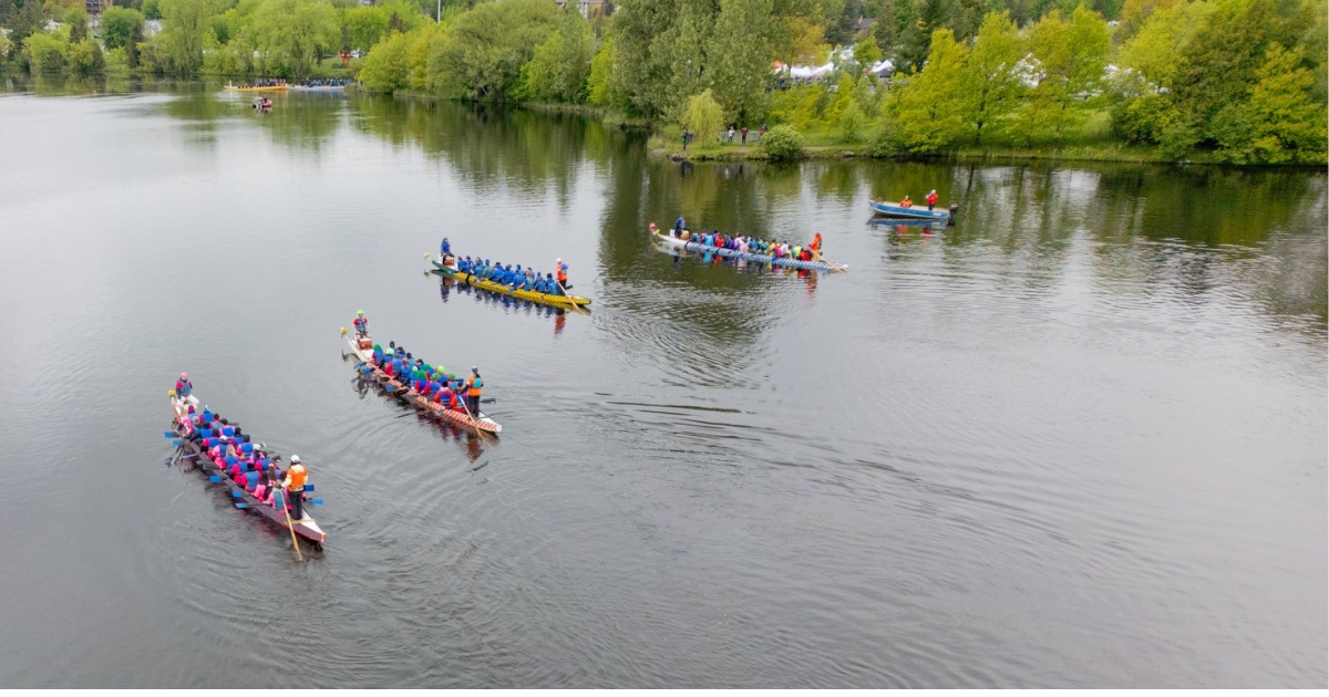 Quatre bateaux-dragons sur l'eau avec un plan en hauteur. 