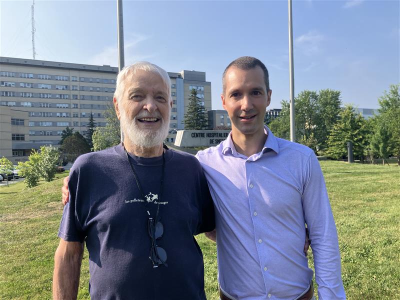 Deux hommes à l'extérieur d'un hôpital.