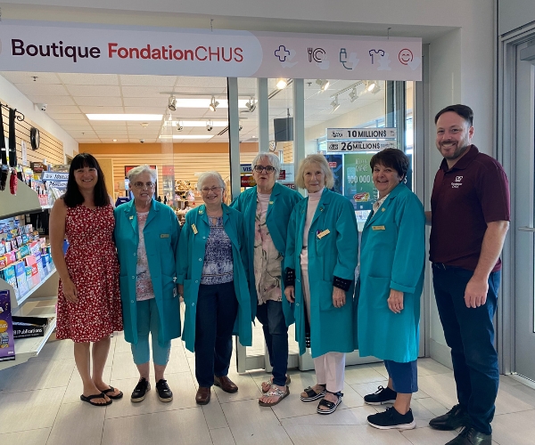 Une équipe devant une boutique.