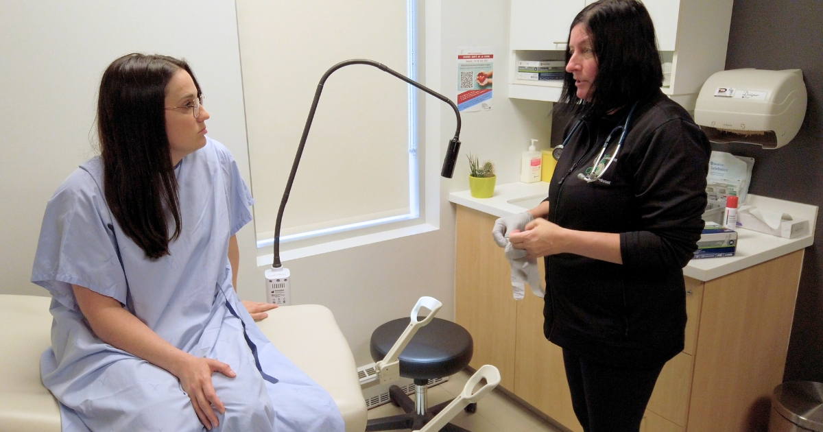 Une patiente et son médecin dans une salle de consultation.<br />
