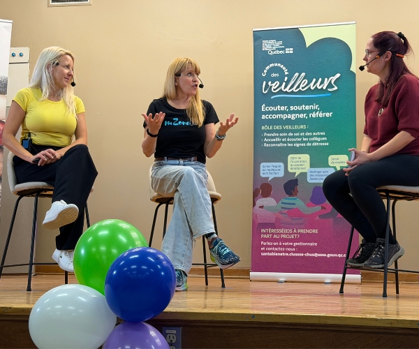 Trois femmes discutent sur un podium.