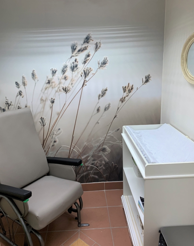 Une salle d'allaitement avec une belle murale reposante.
