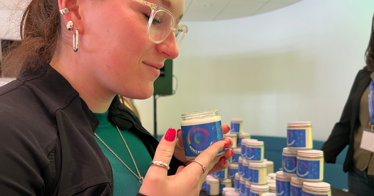 Une femme sent une bougie.