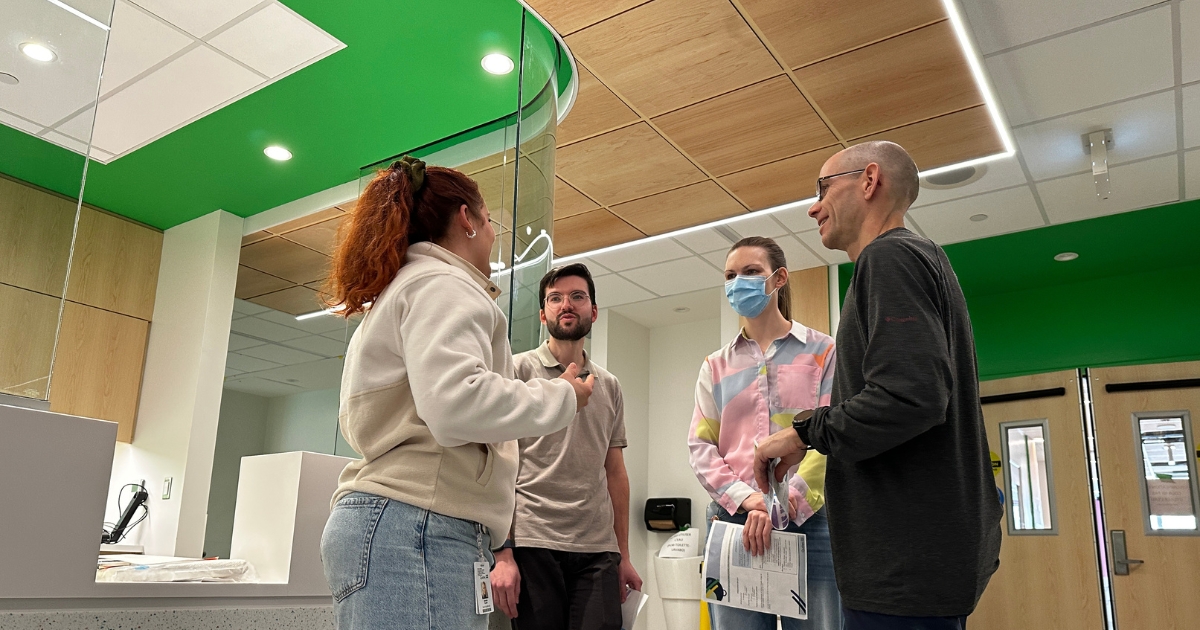 Un groupe de 4 parlent dans un corridor.