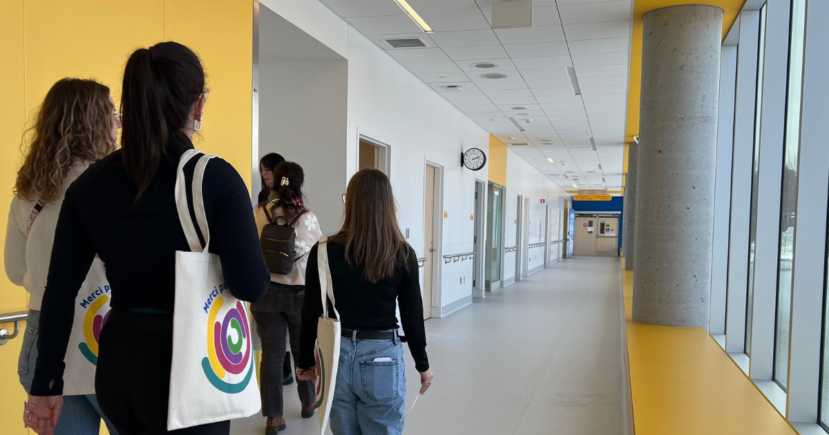 Un groupe de 5 personnes dans un couloir jaune et éclairé. 