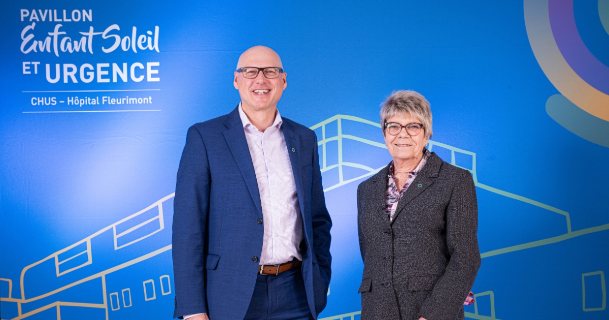 Deux personnes devant un fond bleu.