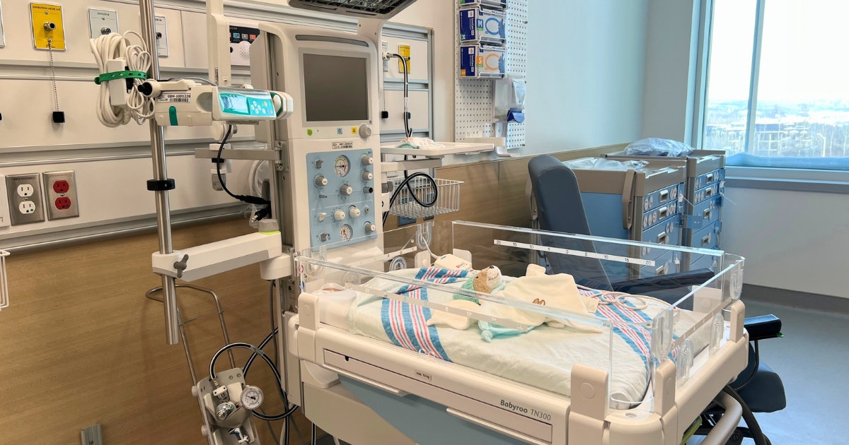 Un petit lit dans une chambre d'hôpital éclairée. 